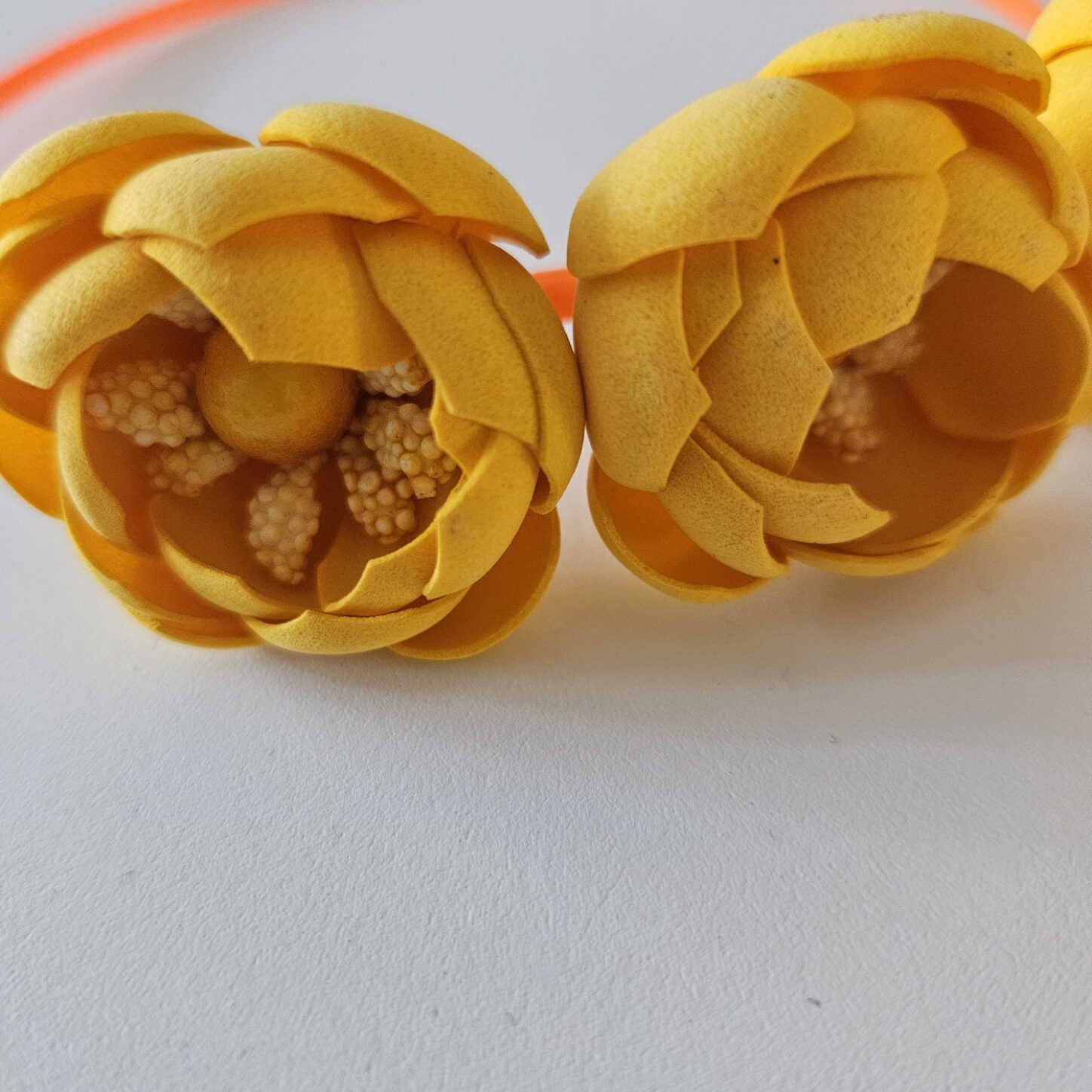 Oranžinis plaukų lankelis su trimis oranžinėmis gėlėmis